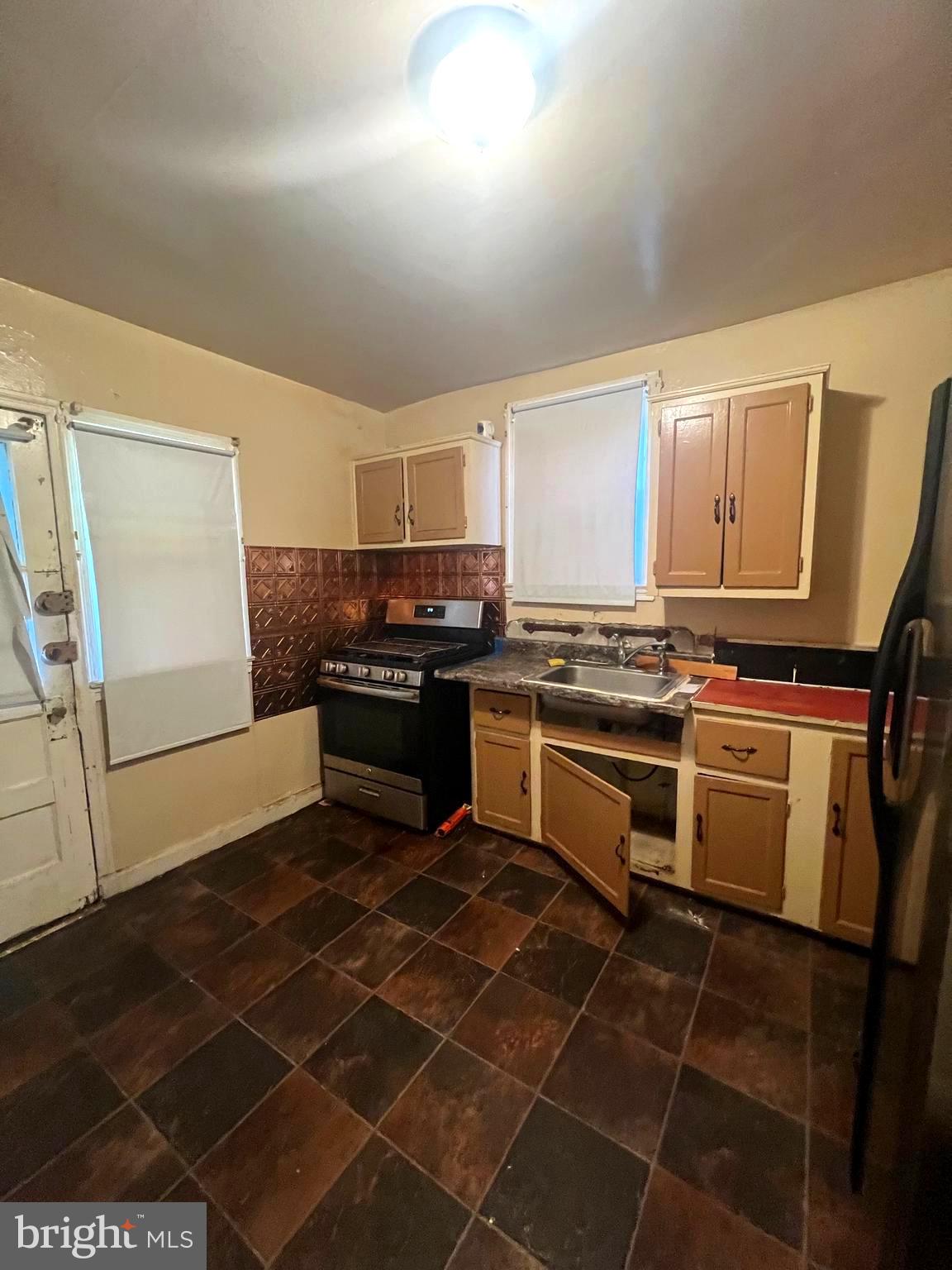 3716 Flowerton Road Baltimore, MD 21229 - Photo 5 of 12 a kitchen with a stove a sink and a refrigerator
