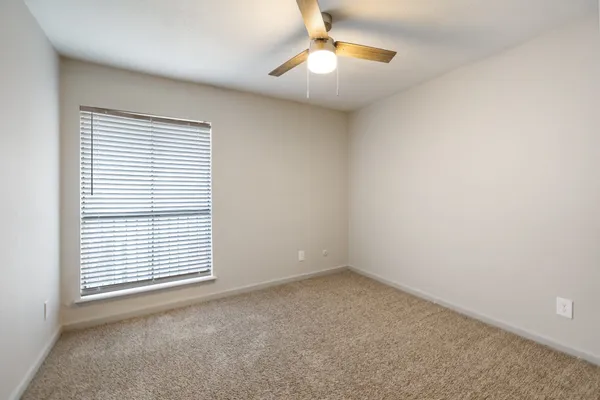 an empty room with a window and fireplace