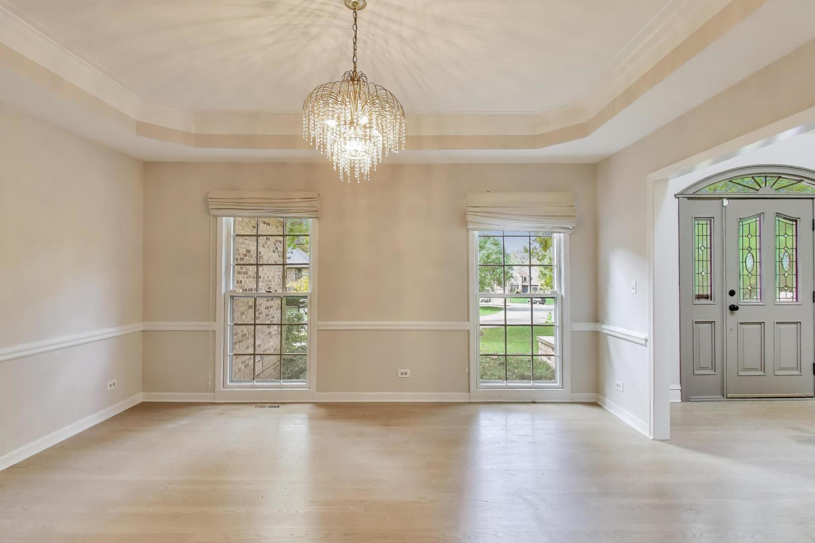 651 Nor-Oaks Court West Chicago, IL 60185 - Photo 15 of 62 an empty room with wooden floor chandelier and windows