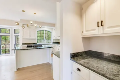 a living room with furniture a fireplace and a chandelier