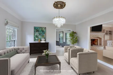 an empty room with wooden floor chandelier and windows