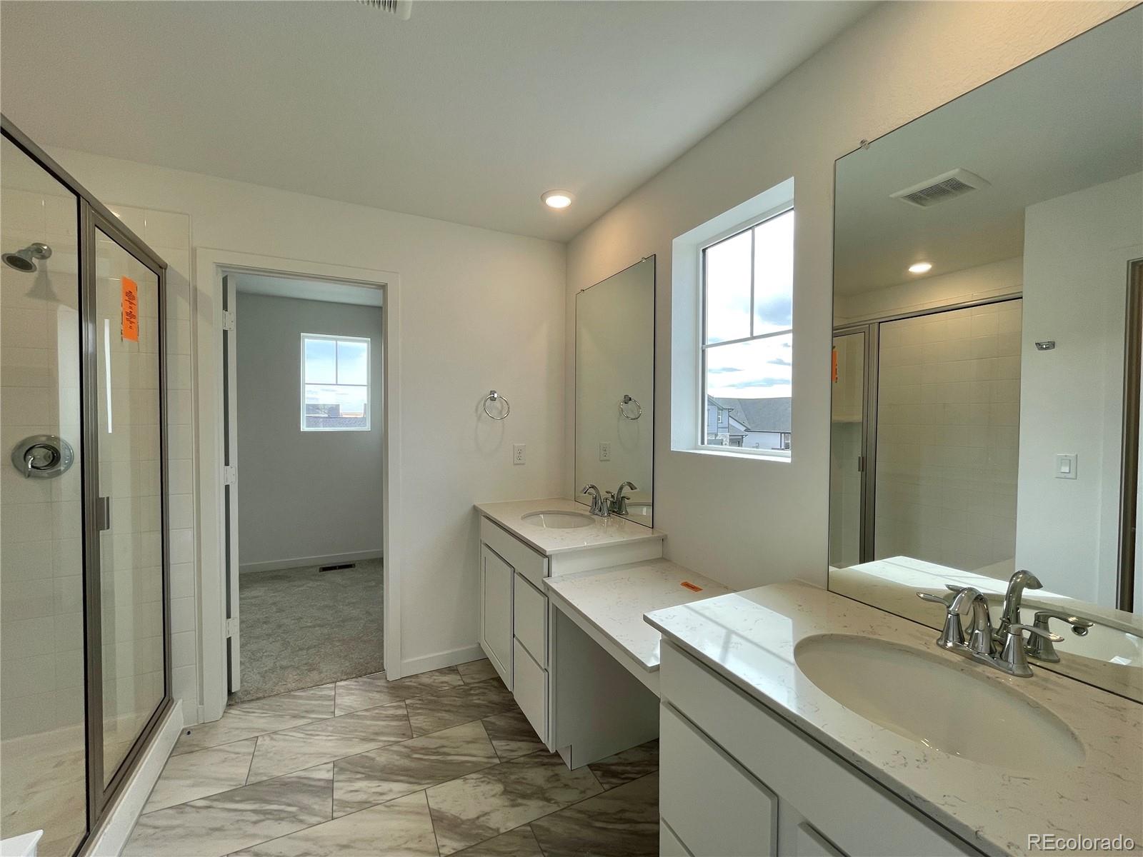 4089 Amanda Drive Johnstown, CO 80534 - Photo 9 of 16 a bathroom with a granite countertop sink mirror and double