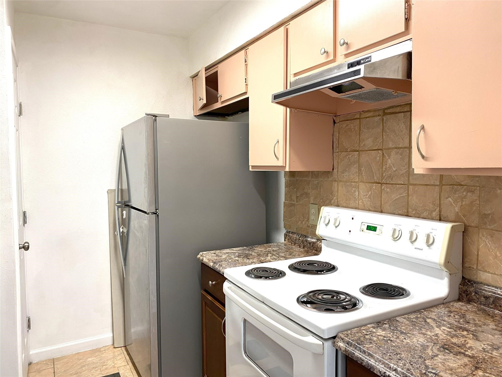 7831 Fuqua Street, Unit 7831 Houston, TX 77075 - Photo 9 of 15 a kitchen with a refrigerator and a stove top oven