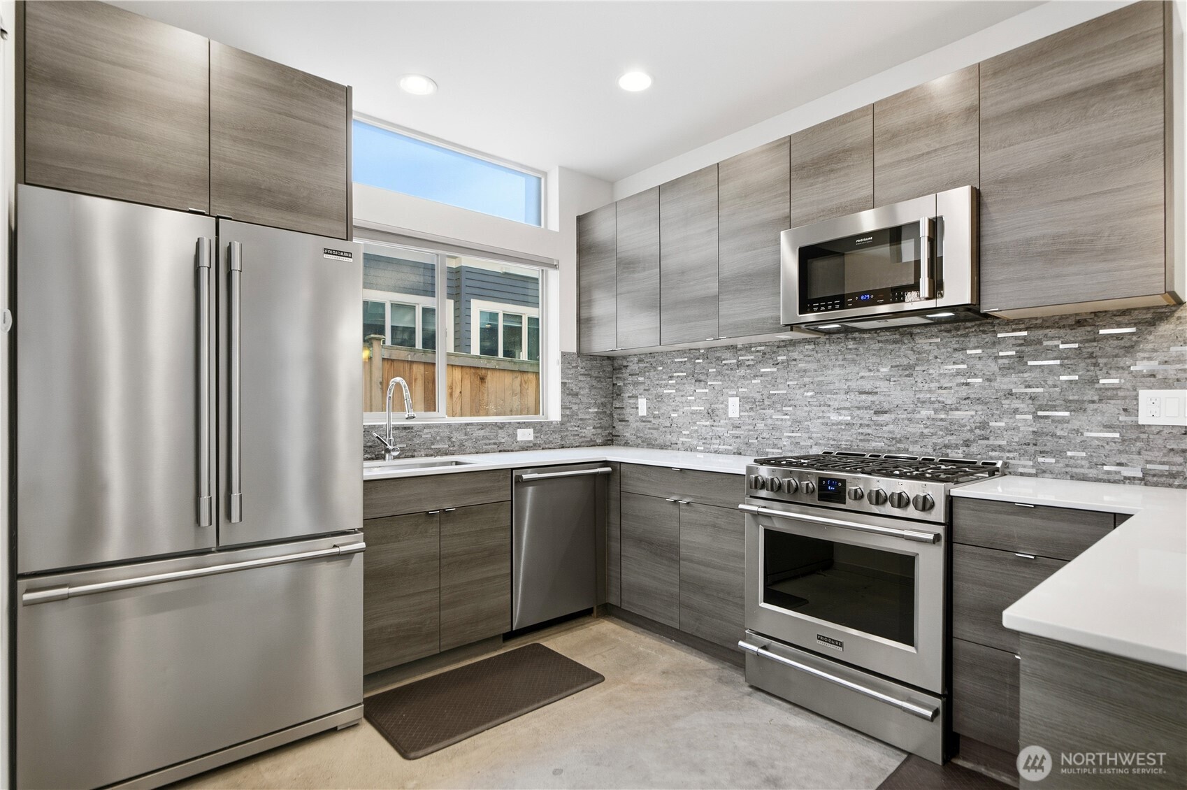 4416 Francis Avenue North, Unit B Seattle, WA 98103 - Photo 7 of 26 a kitchen with stainless steel appliances a refrigerator sink and microwave