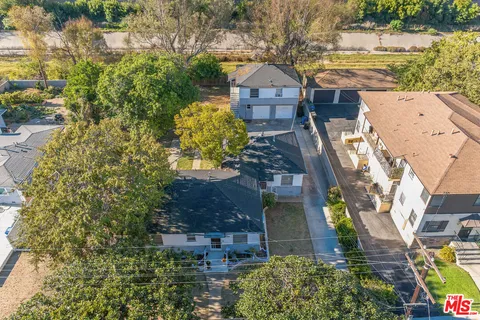 an aerial view of a house with a yard basket ball court and outdoor seating