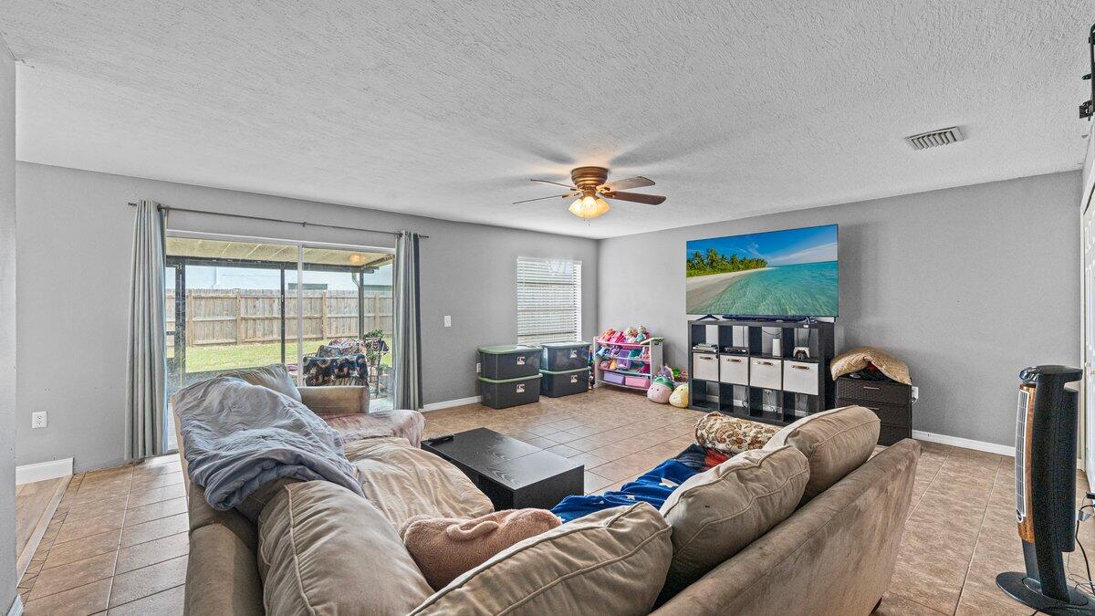 1645 Clover Circle Melbourne, FL 32935 - Photo 15 of 43 a living room with furniture ceiling fan and a window
