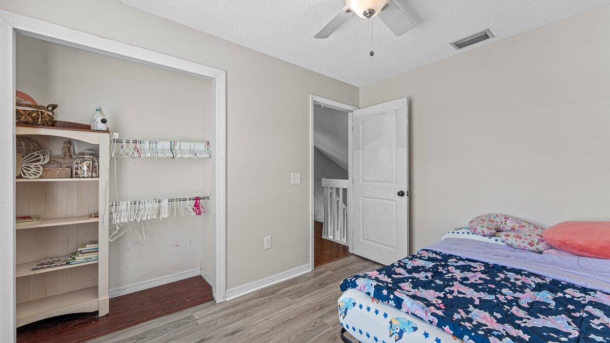 1645 Clover Circle Melbourne, FL 32935 - Photo 21 of 43 a bedroom with a bed and a chandelier