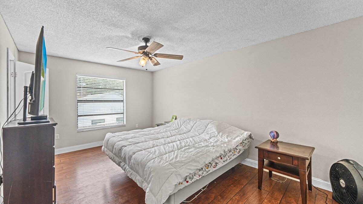 1645 Clover Circle Melbourne, FL 32935 - Photo 23 of 43 a bedroom with a bed and a chandelier