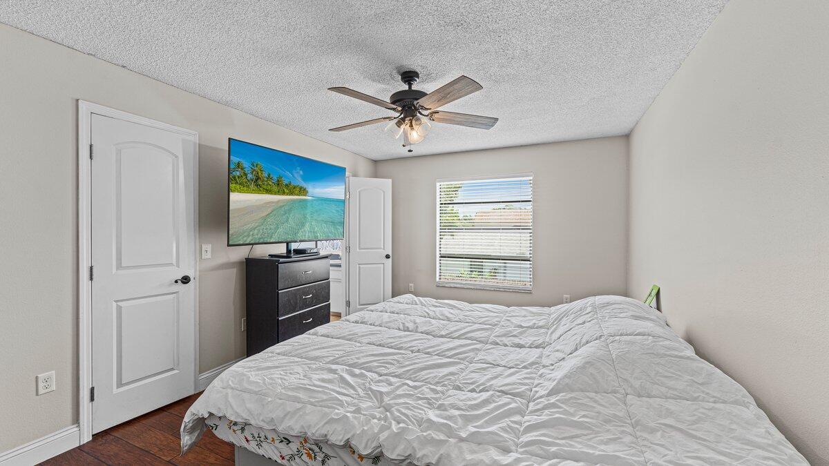 1645 Clover Circle Melbourne, FL 32935 - Photo 24 of 43 a bedroom with a bed and a flat screen tv