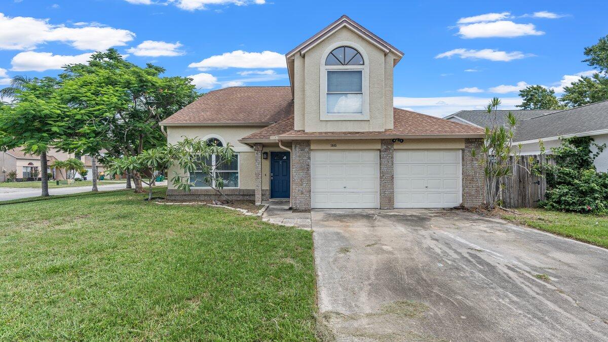 1645 Clover Circle Melbourne, FL 32935 - Photo 32 of 43 a front view of a house with a garden