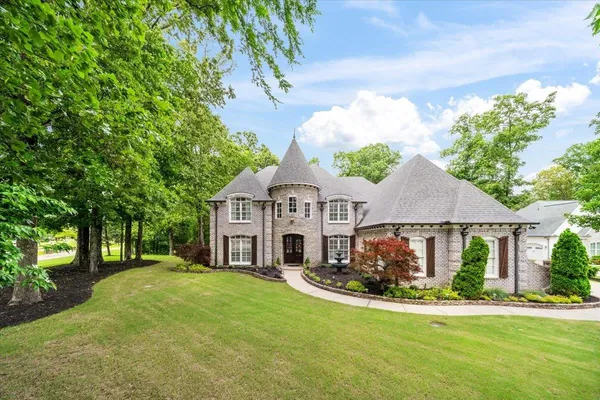 a view of a white house with a big yard and large trees