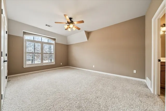 a view of a big room with chandelier fan and windows