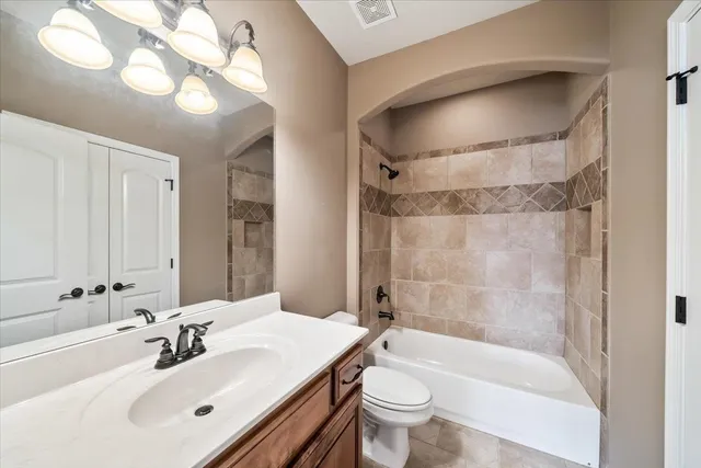 a view of a big room with windows and chandelier fan
