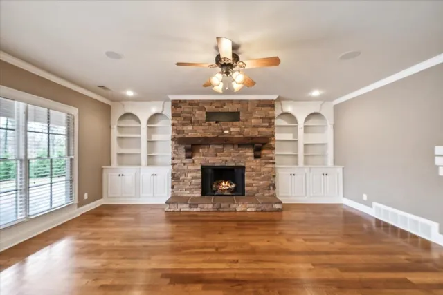 a living room with fireplace and wooden floor