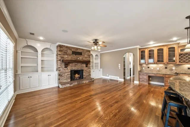 a view of a livingroom with furniture a fireplace and wooden floor