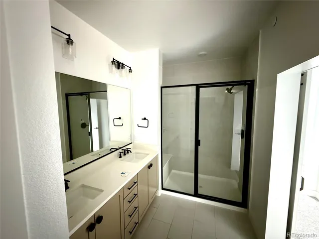 a bathroom with a shower sink and mirror