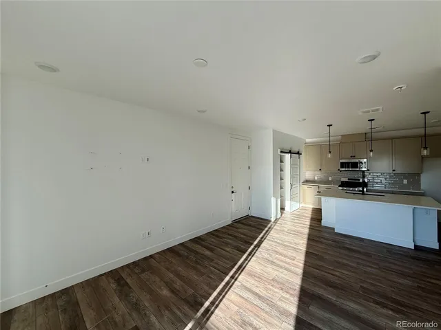 a large kitchen with wooden floor and a sink