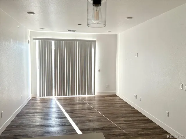 a kitchen view with wooden floor and a view of living room