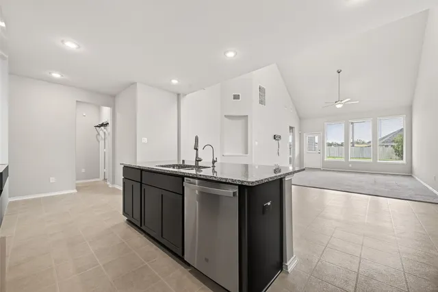 a large kitchen with stainless steel appliances granite countertop a sink and cabinets