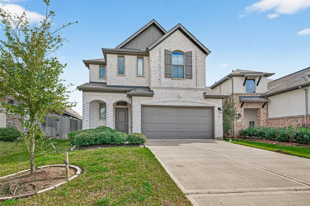 a front view of a house with a yard and garage