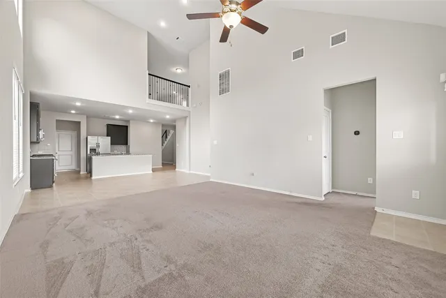 a view of a big room with chandelier fan and kitchen view