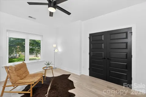 a living room with furniture two window and a flat screen tv