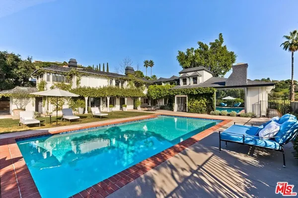 a view of a house with swimming pool and sitting area