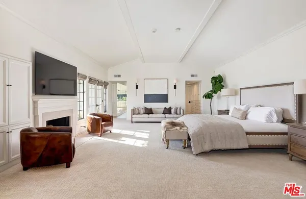 a spacious bedroom with a bed and a fireplace