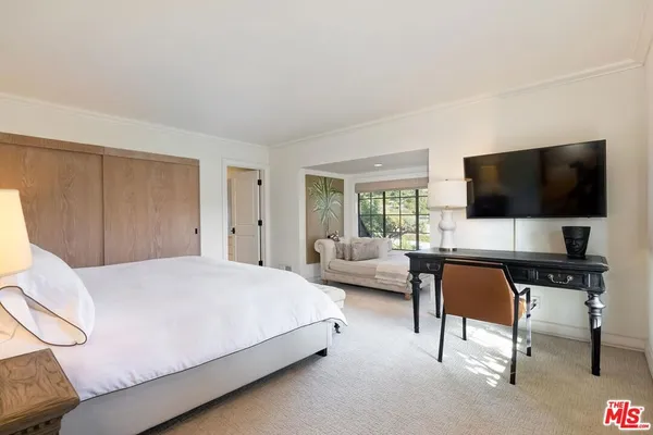 a bedroom with a bed and a flat screen tv