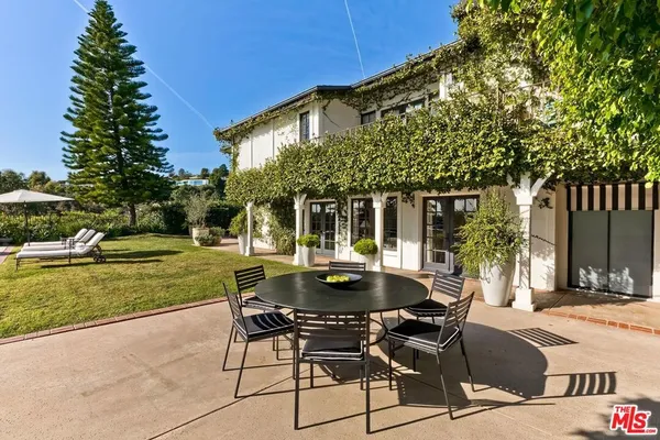 a view of a house with backyard and sitting area