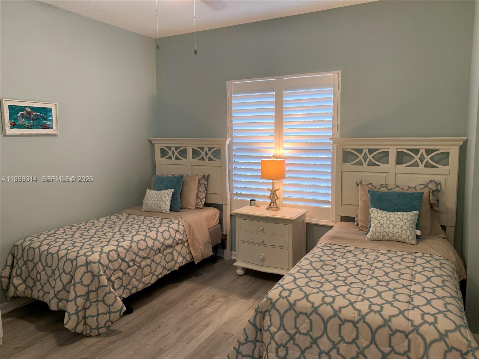 6082 Southeast Landing Way, Unit 10 Stuart, FL 34997 - Photo 13 of 35 a bedroom with a bed and a lamp