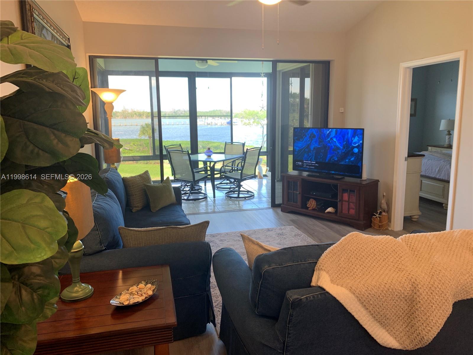 6082 Southeast Landing Way, Unit 10 Stuart, FL 34997 - Photo 25 of 35 a living room with fireplace furniture and a flat screen tv