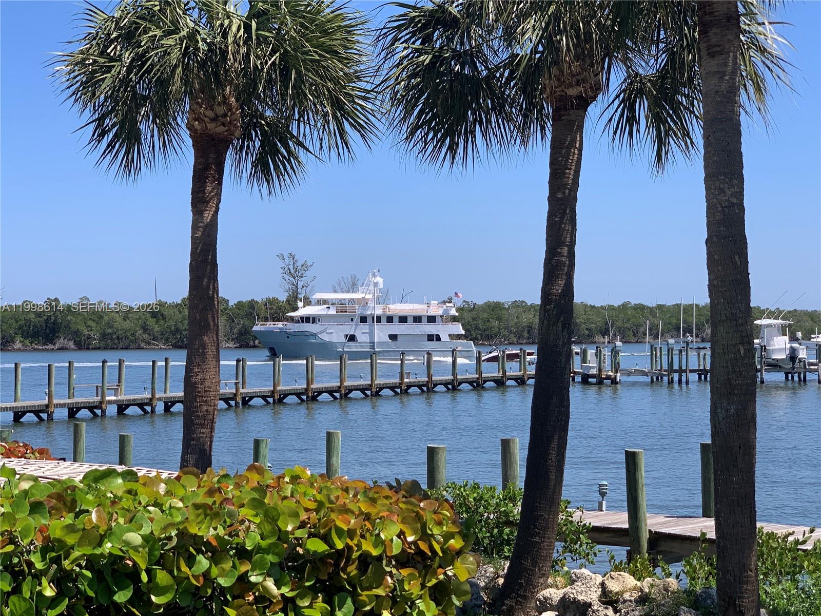 6082 Southeast Landing Way, Unit 10 Stuart, FL 34997 - Photo 3 of 35 a large body of water next to a building with large palm trees