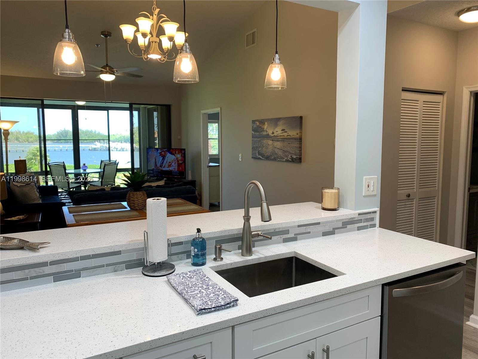 6082 Southeast Landing Way, Unit 10 Stuart, FL 34997 - Photo 4 of 35 a kitchen with a sink and chandelier
