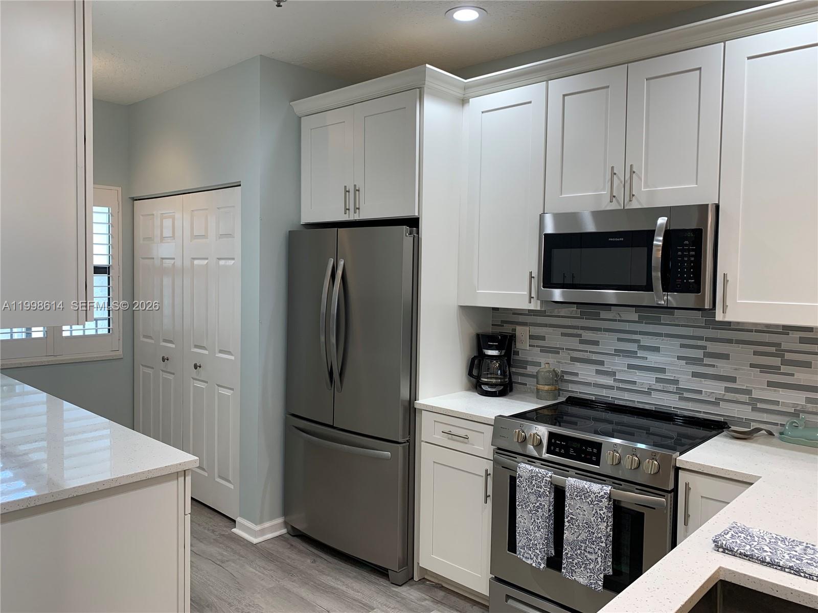6082 Southeast Landing Way, Unit 10 Stuart, FL 34997 - Photo 5 of 35 a kitchen with a refrigerator stove and microwave