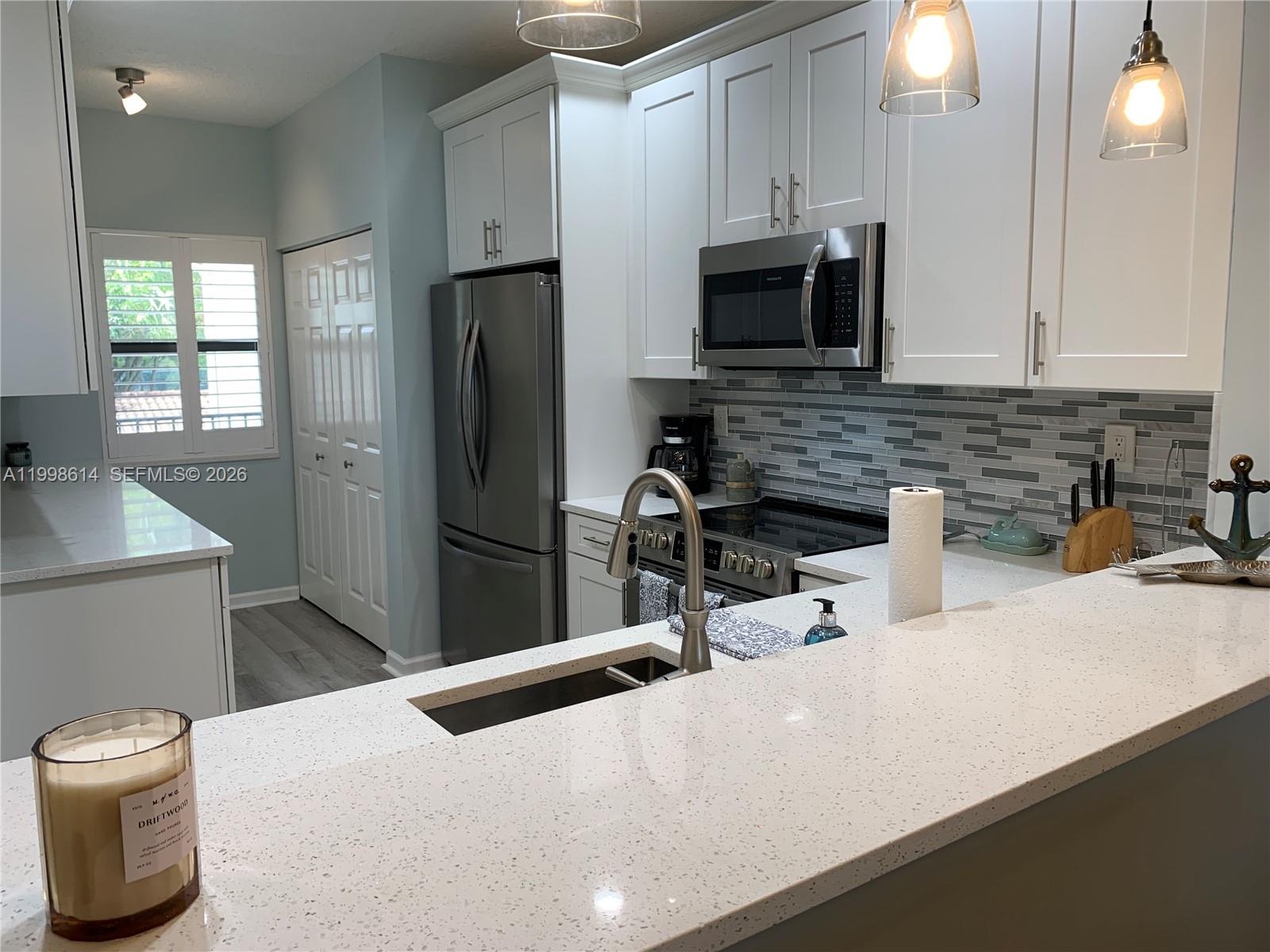 6082 Southeast Landing Way, Unit 10 Stuart, FL 34997 - Photo 6 of 35 a kitchen with stainless steel appliances a refrigerator sink and microwave