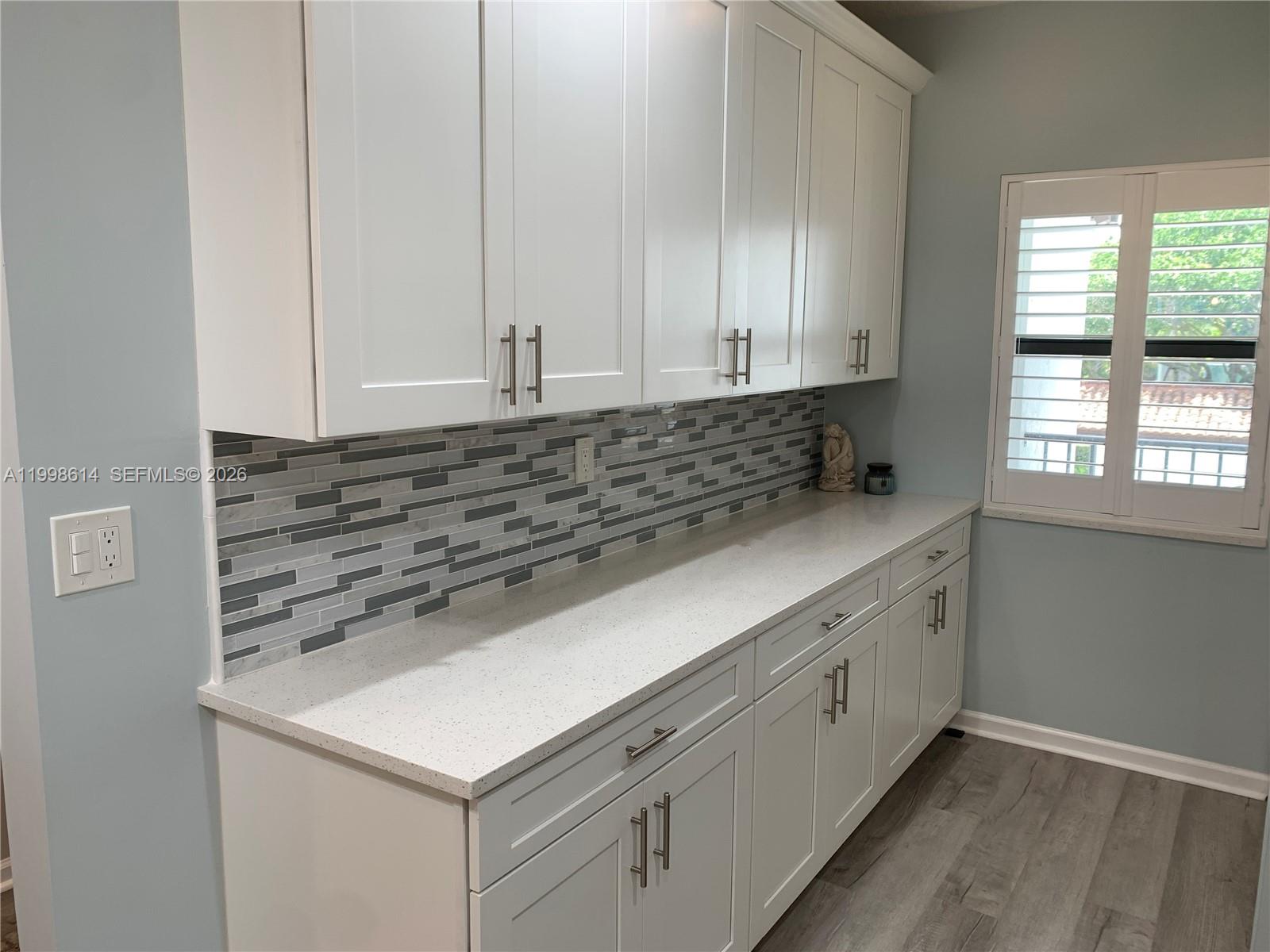 6082 Southeast Landing Way, Unit 10 Stuart, FL 34997 - Photo 8 of 35 a kitchen with granite countertop white cabinets and window