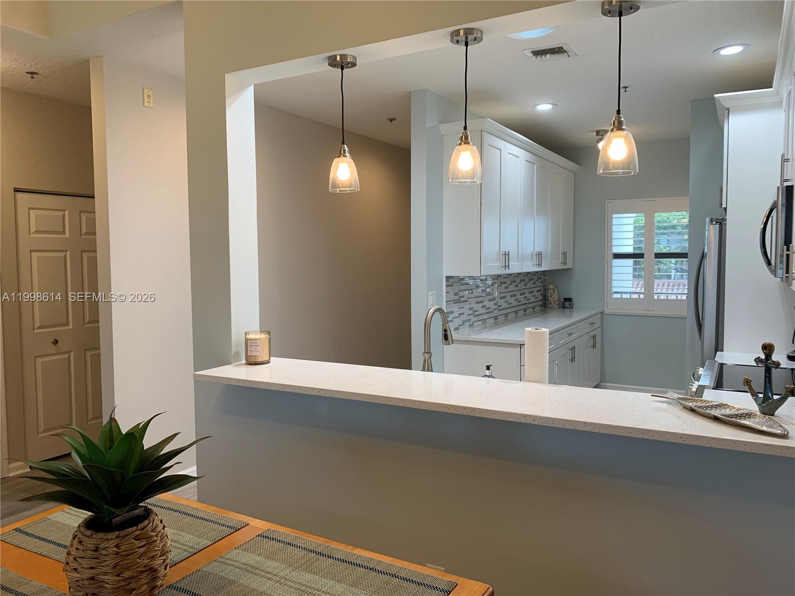 6082 Southeast Landing Way, Unit 10 Stuart, FL 34997 - Photo 10 of 35 a bathroom with a double vanity sink a large mirror and a shower