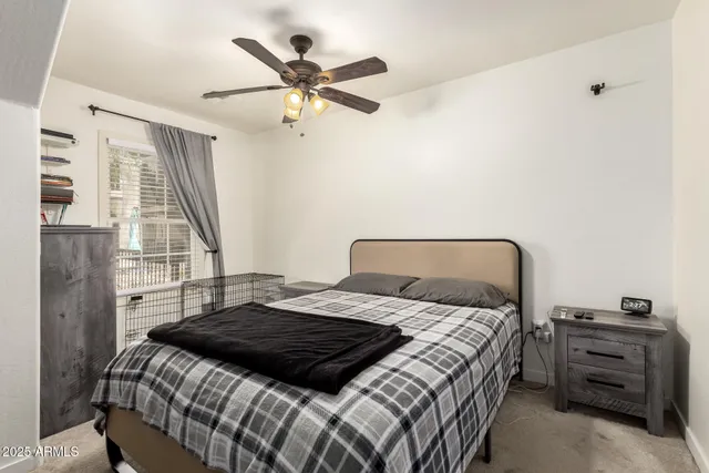 a bedroom with a bed and a flat tv screen on dresser