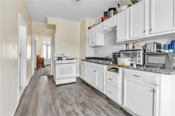 a kitchen with granite countertop white cabinets and white appliances