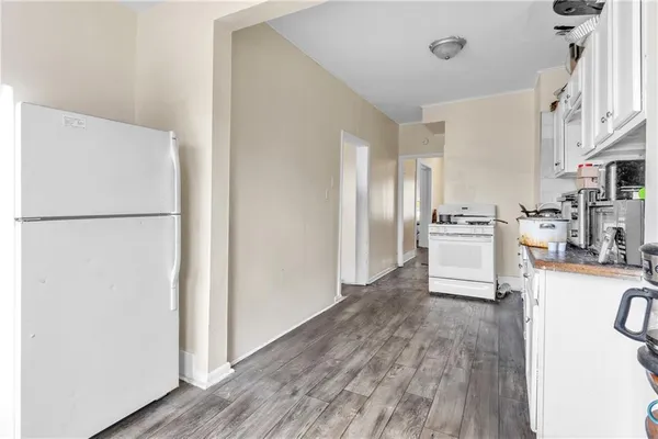 a kitchen with stainless steel appliances granite countertop a refrigerator sink and white cabinets