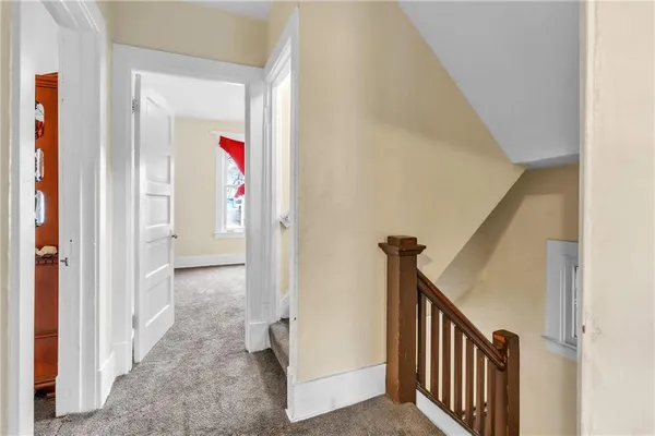 a view of a hallway with wooden floor and entryway