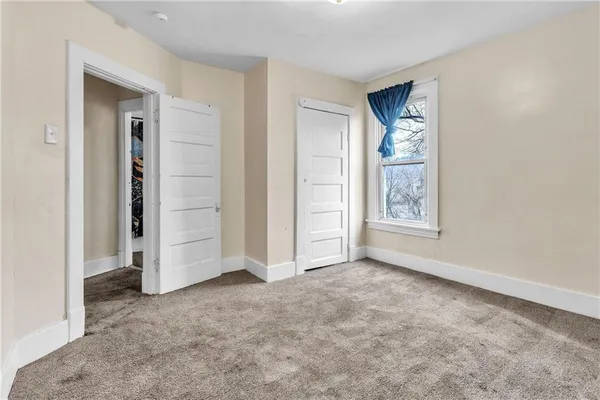 an empty room with windows and closet