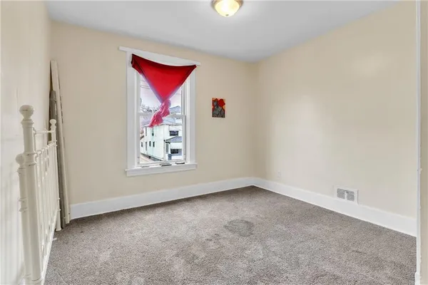 an empty room with windows and cabinet