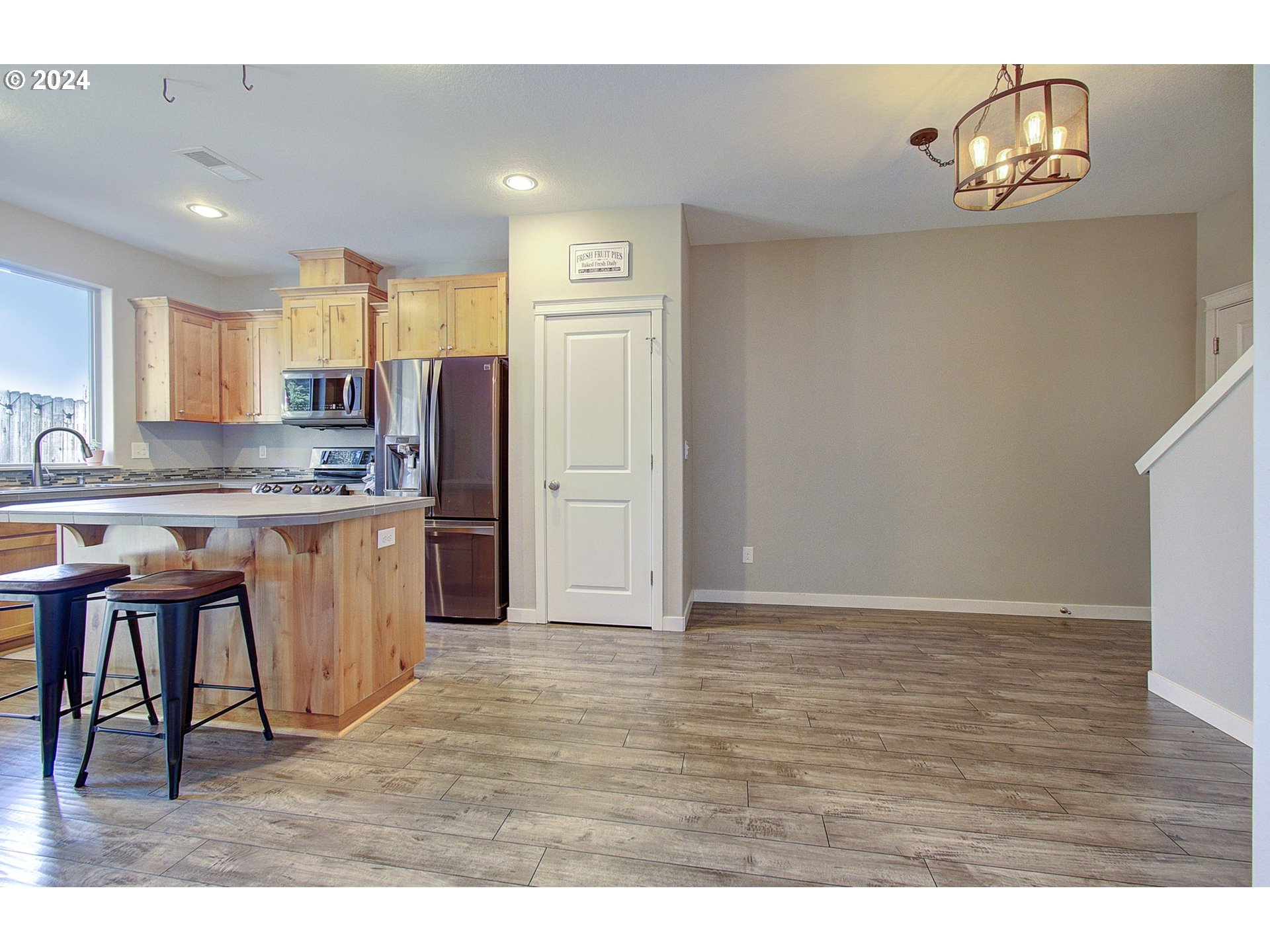 146 North 44th Place Ridgefield, WA 98642 - Photo 11 of 30 a kitchen with kitchen island granite countertop wooden floors and white cabinets