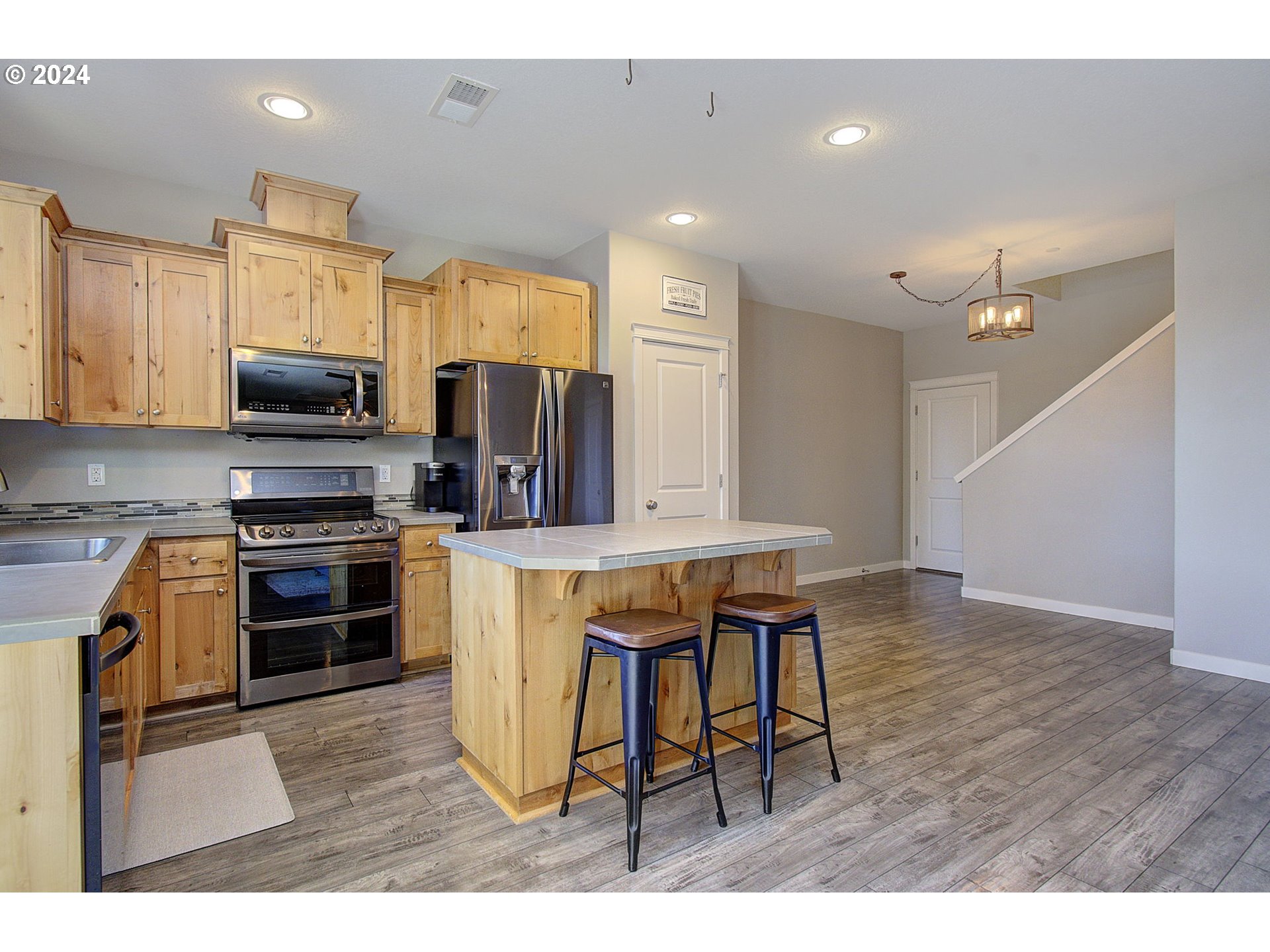 146 North 44th Place Ridgefield, WA 98642 - Photo 7 of 30 a kitchen with stainless steel appliances kitchen island granite countertop a stove a sink and a microwave