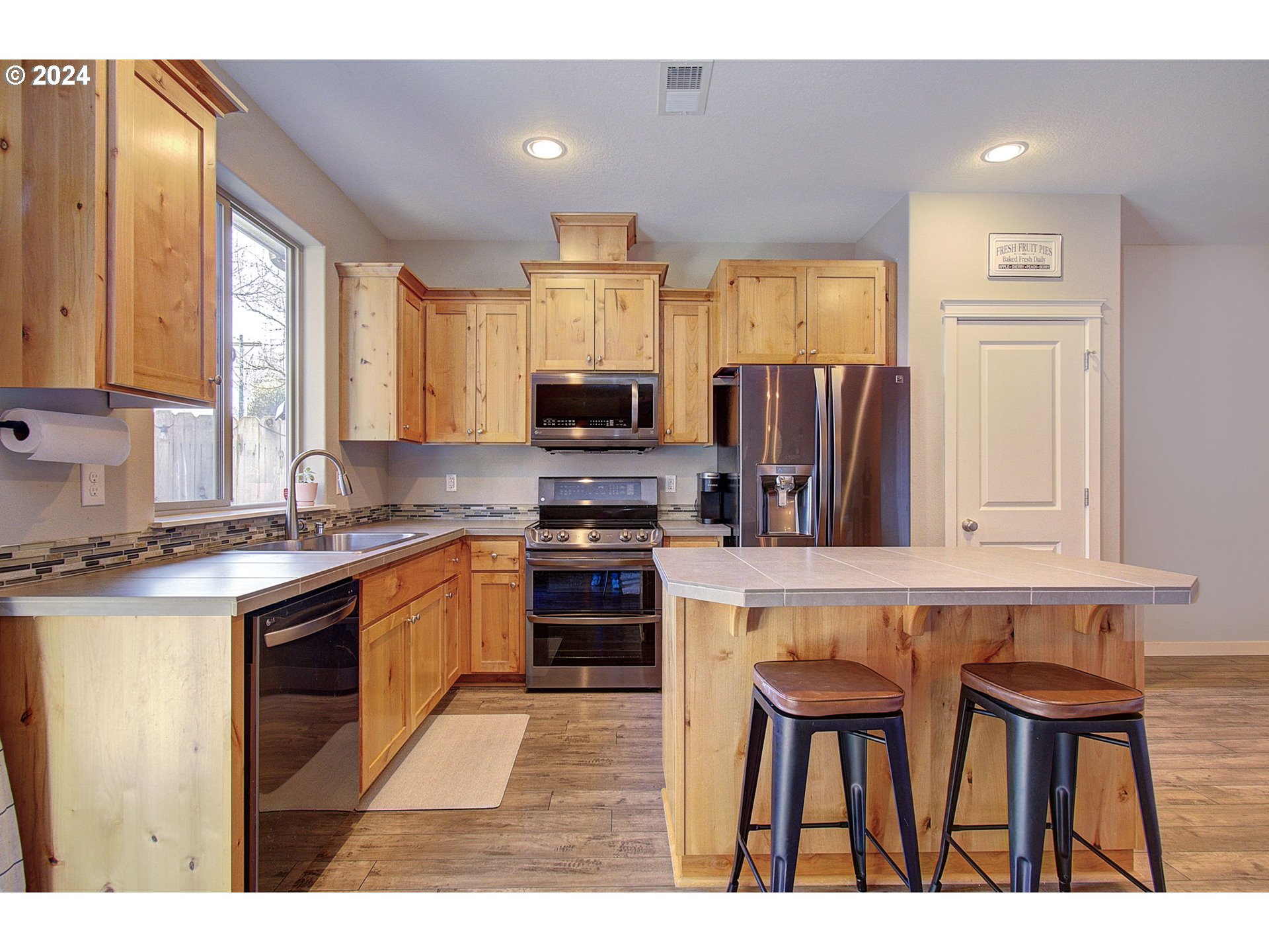 146 North 44th Place Ridgefield, WA 98642 - Photo 8 of 30 a kitchen with stainless steel appliances granite countertop a stove top oven a refrigerator a sink and a dining table with wooden floor