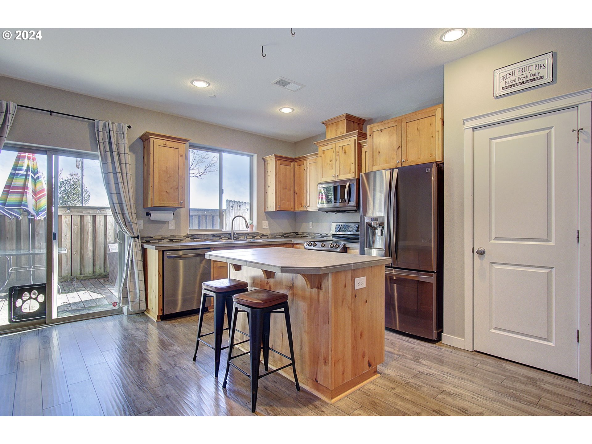 146 North 44th Place Ridgefield, WA 98642 - Photo 9 of 30 a kitchen with stainless steel appliances granite countertop a refrigerator a sink dishwasher a stove and a dining table with wooden floor