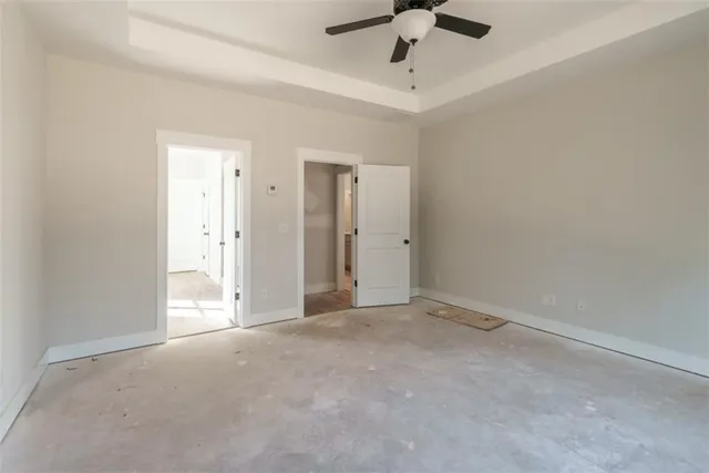 an empty room with a ceiling fan and carpet