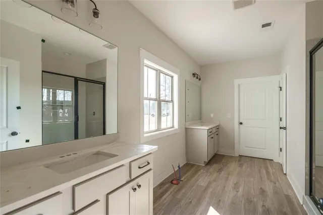 a spacious bathroom with a granite countertop sink mirror and a bathtub